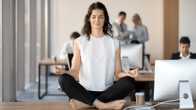 Frau meditiert bei der Arbeit - Wohlbefinden am Arbeitsplatz