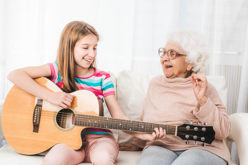 Großeltern und Enkelin mit Gitarre