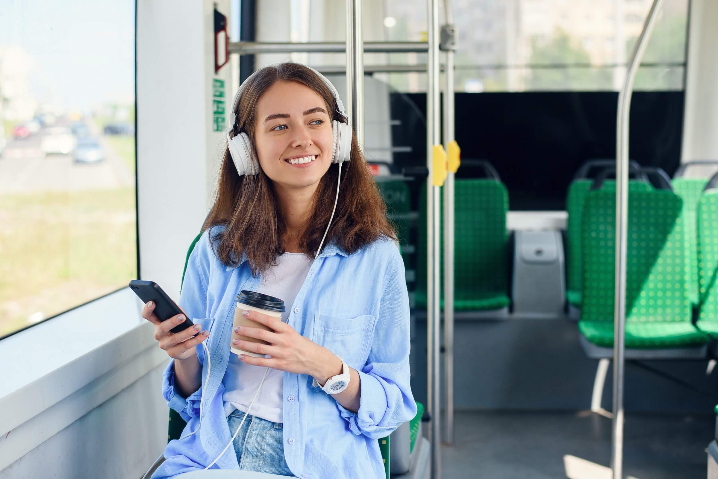 Frau hört im Zug Musik um gut gelaunt in den Tag zu starten