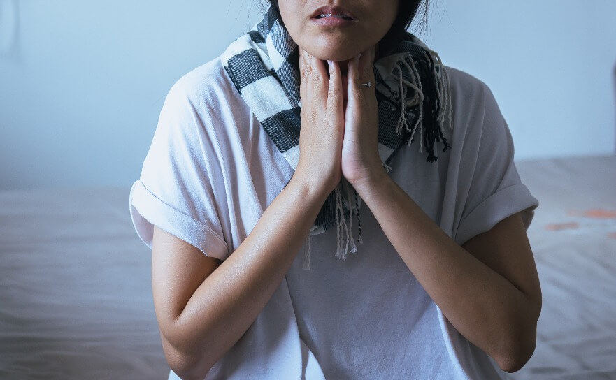 Frau mit Schnupfen und Halsweh