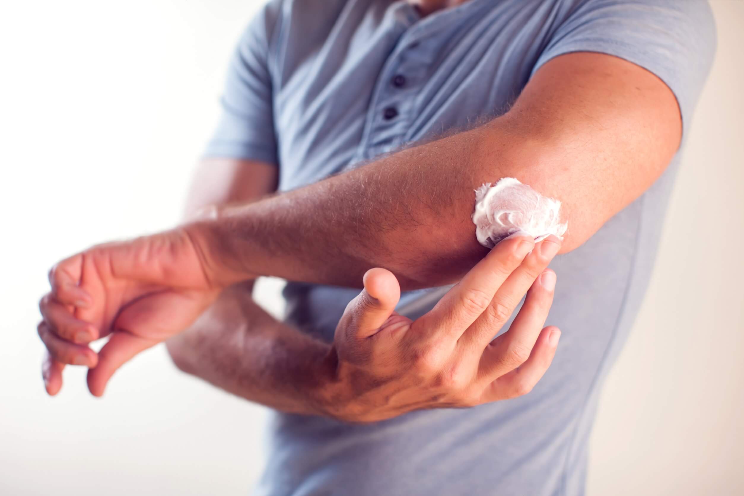 Mann mit Gelenkschmerzen verwendet Gelenkcreme